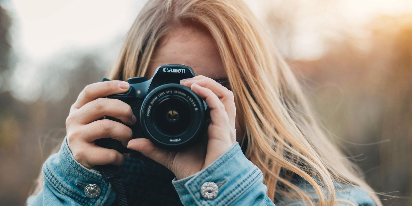 foto de uma mulher fotografando com uma câmera canon