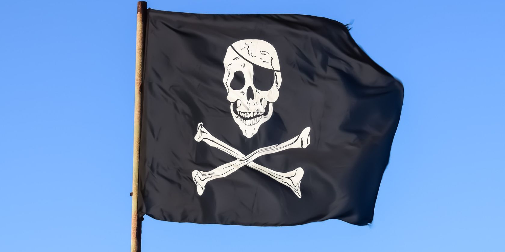 Uma bandeira negra com uma caveira branca e ossos cruzados