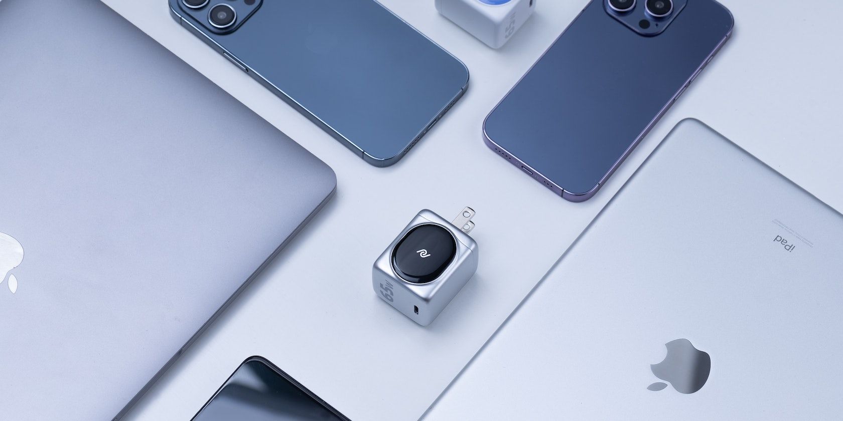 iPhones, um Mac e um iPad dispostos em uma superfície branca